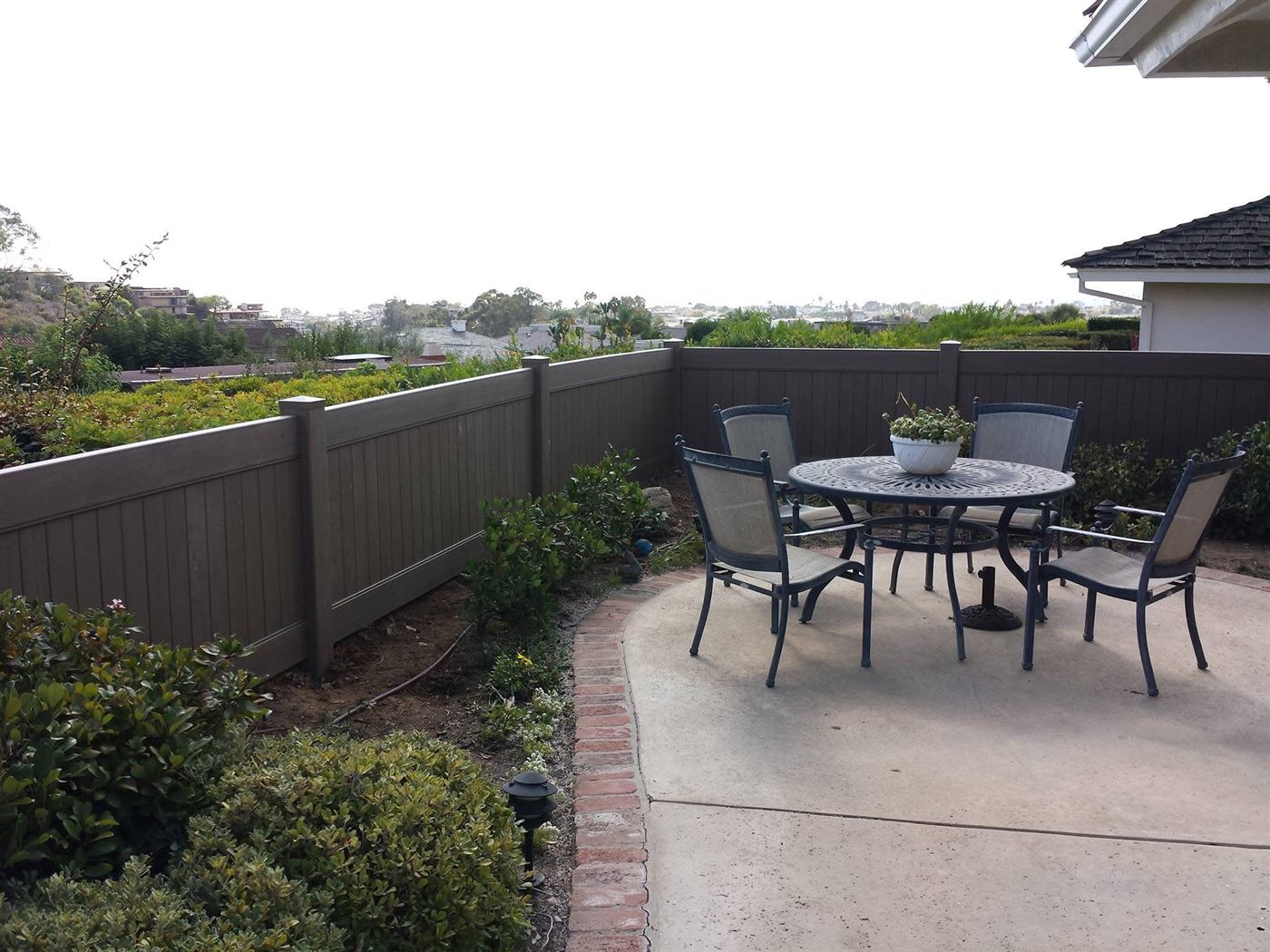Vinyl privacy fence along a landscaped backyard